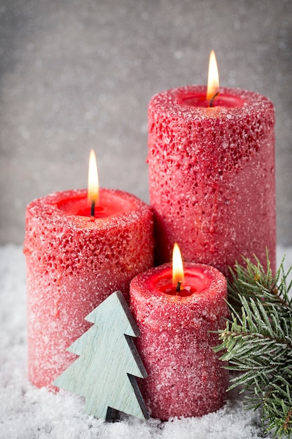 Drei rote Kerzen auf grauer Oberfläche, Weihnachtsdekoration. Adventsstimmung.