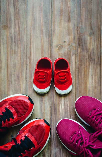 Drei rote Sportlaufschuhe oder Turnschuhe der Mutter und des Vaters und des Kindes