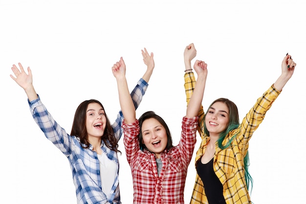 Drei schöne junge Mädchen mit erhobenen Händen glücklich. isoliert auf weißer Wand Mit Copyspace
