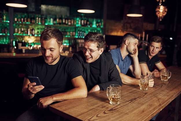 Drei Sportfans in einer Bar beim Fußball gucken