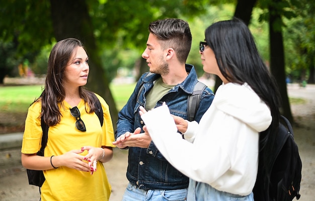 Drei Studenten unterhalten sich im Freien in einem College-Hof