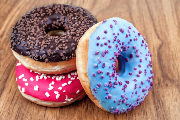 Drei süße Donuts auf Holzhintergrund