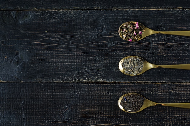 Drei Teesorten in Löffeln - grün, schwarz und Rooibos