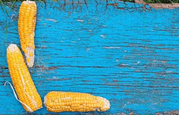 Foto drei trockene maisstücke liegen auf einem alten holztisch