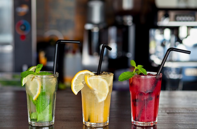 Foto drei verschiedene erfrischende limonade mit zitrone und limette an der bar im cafe. sommergetränk