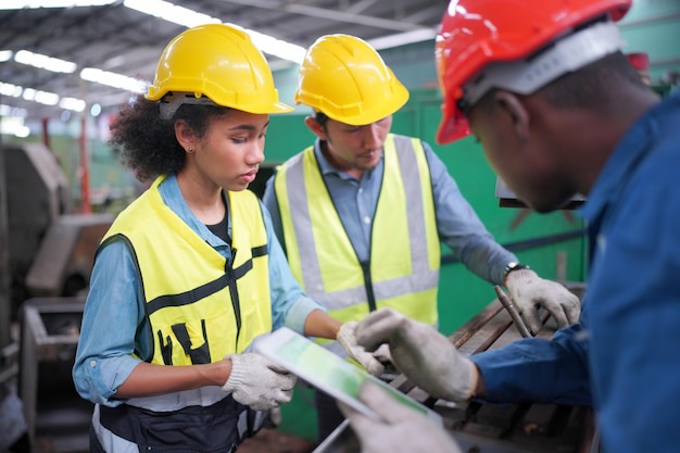 Drei verschiedene multikulturelle Ingenieure und Arbeiter der Schwerindustrie in Uniform in der Stahlfabrik