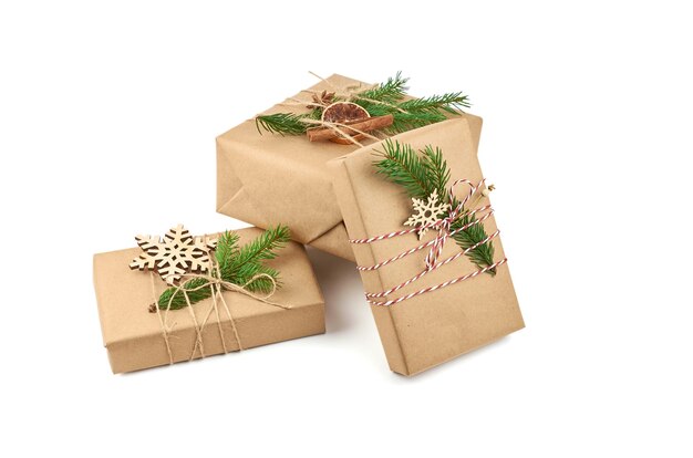Drei Weihnachtsgeschenkboxen mit festlicher Dekoration und Tannenzweigen