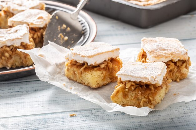 Drei Würfel Apfelkuchen mit einem verquirlten Wgg-Weiß auf einer Serviette mit mehr Kuchen auf der Rückseite.