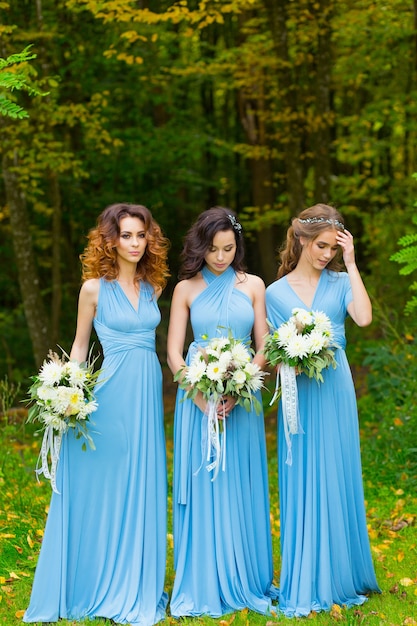 Drei wunderschöne Brautjungfern im Park am Hochzeitstag