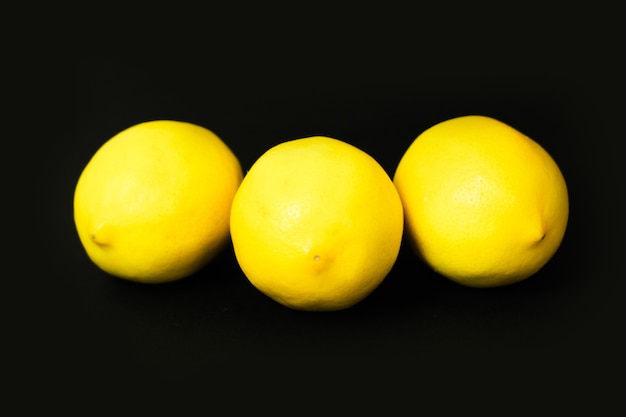 Drei Zitronen auf schwarzem Hintergrund