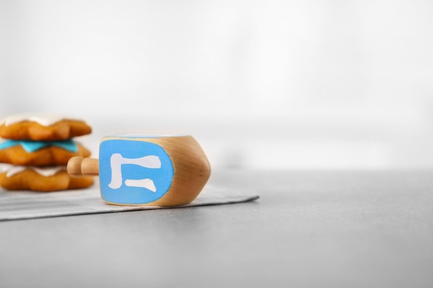 Dreidel de madera para Hanukkah sobre mesa gris sobre fondo claro