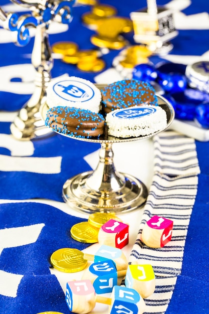 Dreidels coloridos de Hanukkah y gelt de oro sobre la mesa.