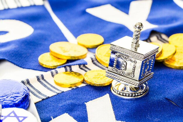 Dreidels de Hanukkah coloridos e gelt de ouro na mesa.