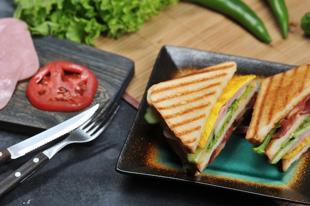 Dreieckige Sandwiches mit Schinken und Omelett auf einem Teller