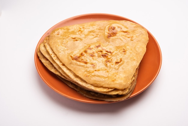 Dreiecksform Plain Paratha oder Parantha ist ein leckeres indisches Fladenbrot aus Vollkornmehl. in einem Teller serviert, selektiver Fokus