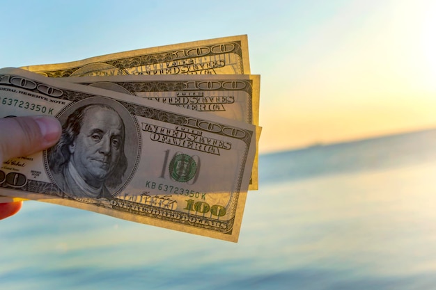 Dreihundert-Dollar-Scheine auf dem Hintergrund von Dollar-Bargeld an der Meeresoberfläche