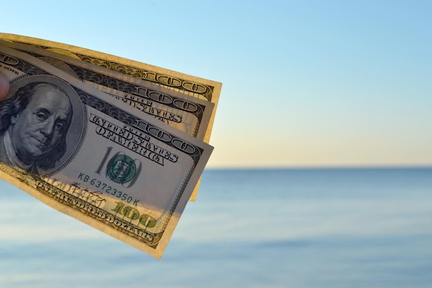 Dreihundert-Dollar-Scheine auf dem Hintergrund von Dollar-Bargeld an der Meeresoberfläche