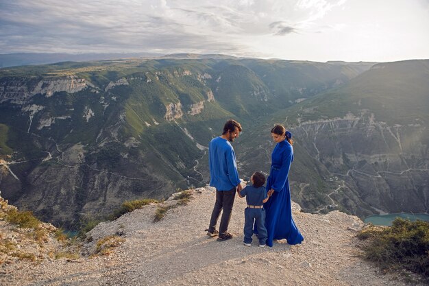 Dreiköpfige Familie steht auf der Bergschlucht bei Sonnenuntergang in Dagestan