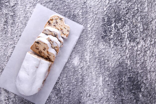 Dresdner Stollen es un pastel tradicional alemán con pasas sobre fondo gris con lugar para texto. Pastel de frutas para las vacaciones.