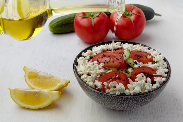 Dressing mit Olivenöl Salat aus frischen Tomaten Gurken Hüttenkäse und Schwarzkümmel