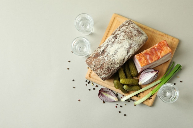 Drinques e lanches saborosos na parede cinza claro, vista de cima