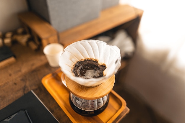 Drip coffee, barista derramando água no café moído com filtro, brewing coffee