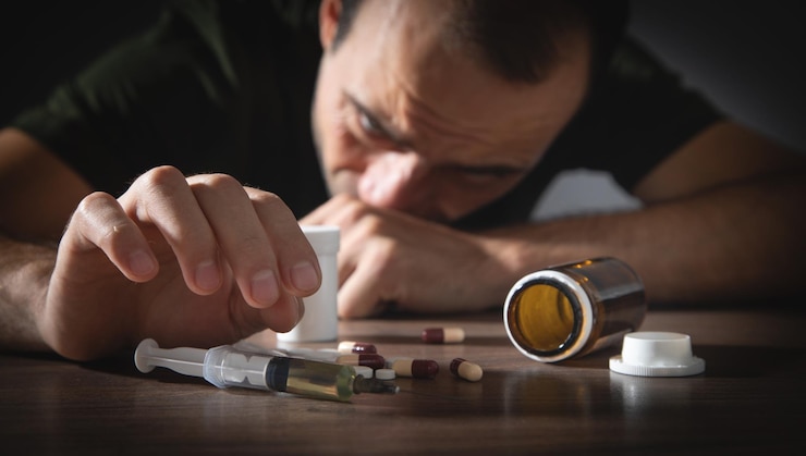 Foto drogadicto hombre con una jeringa y drogas adicción