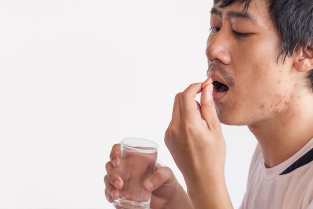 Drogas na mão paciente, colorido de comer medicamentos no fundo branco