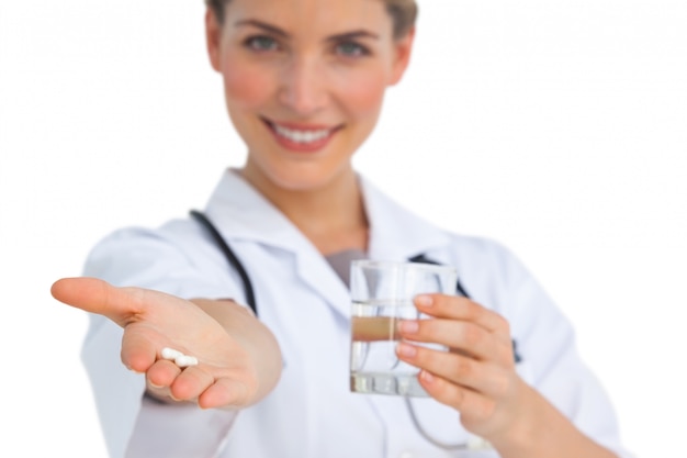 Drogen und Wasserglas von Krankenschwester gehalten