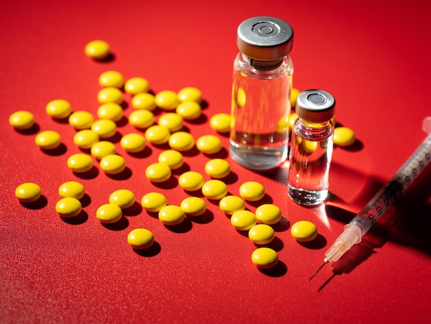 Drogenflasche und Pillen auf rotem Hintergrund