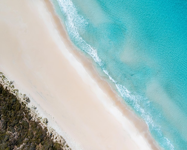 Drohnen-Aufnahme eines himmlischen Sandstrandes und kristallklares blaufarbenes Meerwasser