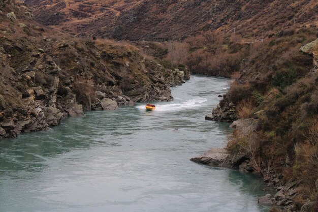 Foto drohnen-aufnahme von menschen, die in einem fluss inmitten eines berges rafting machen