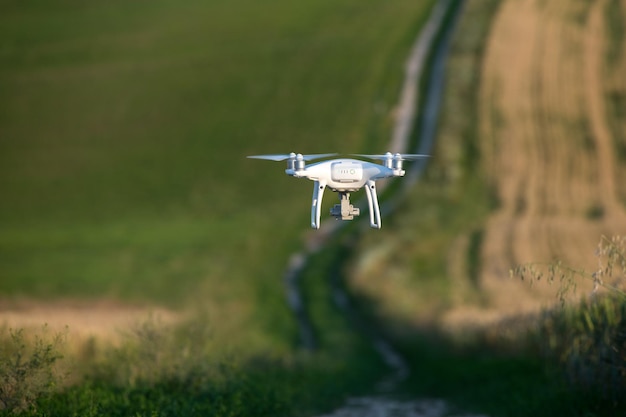 Drohnen-Quadcopter, der im Sommer über die grüne Wiese fliegt. Technologieinnovation in der Agrarindustrie