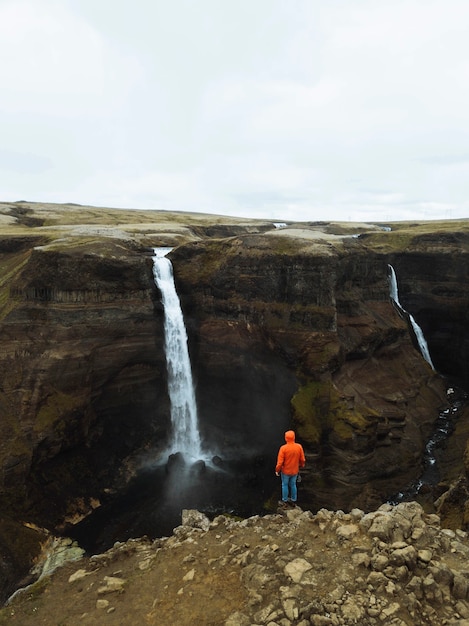 Drohnenaufnahme eines Mannes am Wasserfall Haifoss, Island