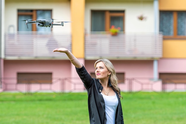 Drohnenlandung auf den Händen der jungen blonden Frau modernes Technologiekonzept