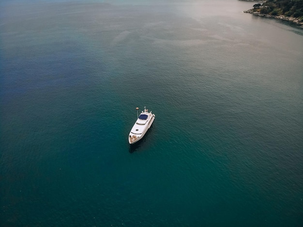 Drohnenschuss der schönen weißen Yacht im warmen blauen Meer; Millionär Konzept.