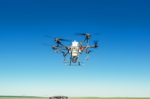 Dron agrícola en vuelo sobre un fondo de cielo azul Campo rociando nuevas tecnologías