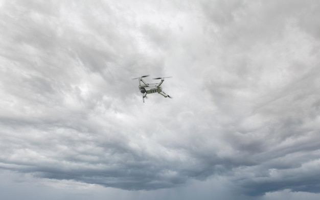 Un dron de alta tecnología en el cielo Un dron de filmación profesional vuela en el aire a baja altura contra un cielo azul y una playa de arena marina El dron hace fotos Nueva tecnología moderna