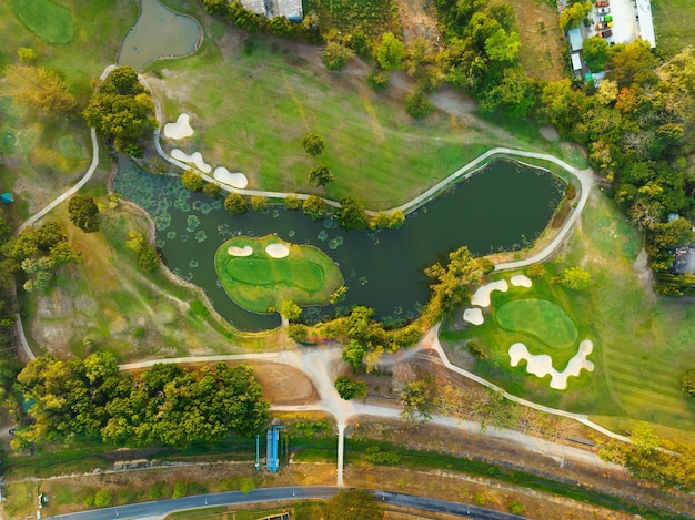 Dron de vista aérea Toma de arriba hacia abajo del hermoso campo de golf verde Vista de ángulo alto en el atardecer