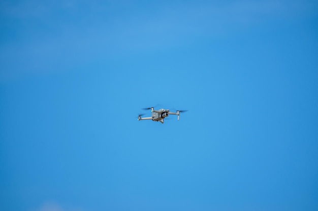 Un dron vuela en el cielo con un fondo de cielo azul.