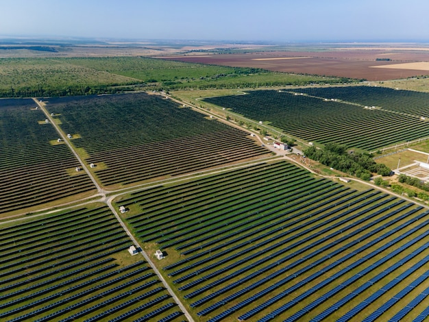 Drone aéreo atirou em campo verde urbano moderno eco energia solar bateria estação de energia renovável na Crimeia no verão