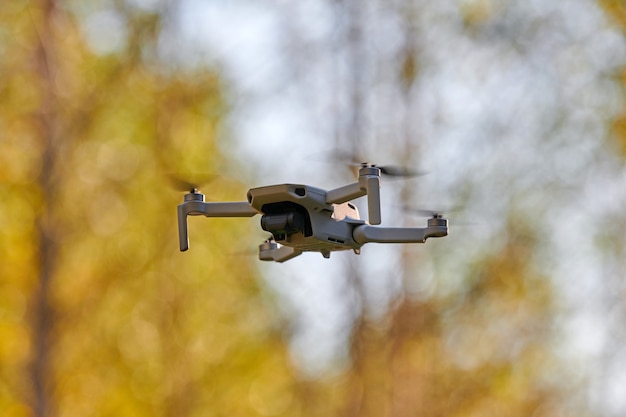 Drone cuadricóptero en el cielo. Pequeño avión no tripulado vuela en el cielo tomando videos y fotos.