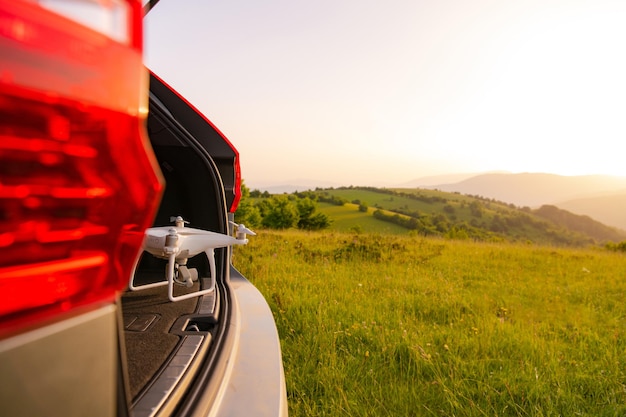 drone listo para volar en suv baúl paisaje naturaleza montañas puesta de sol