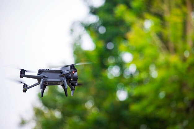 Drone moderno voa na floresta Drone escuro no ar contra