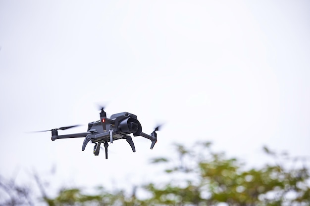 Drone moderno voa na floresta Drone escuro no ar contra
