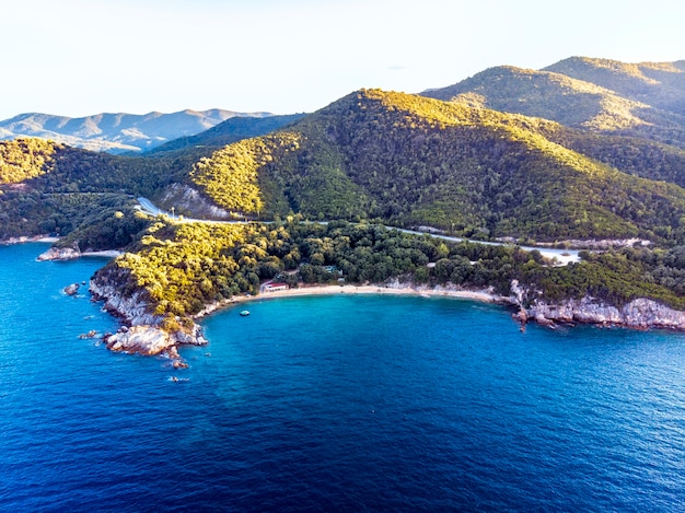 Drone panorama del atardecer en Halkidiki con mar azul y montañas, Grecia