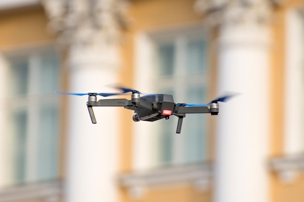 Drone quad copter está volando contra el fondo de ventanas y columnas de un edificio antiguo