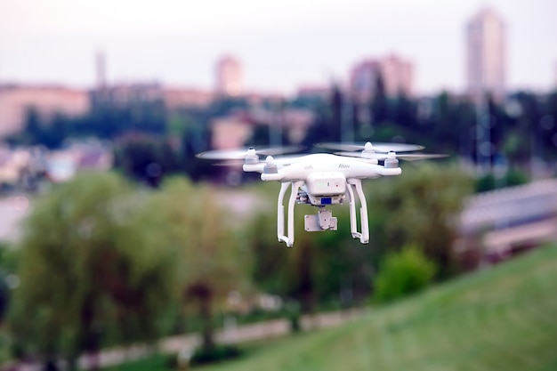 Drone quad helicóptero com câmera digital de alta resolução voando pairando sobre a cidade