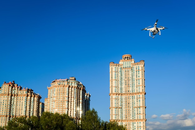 Drone quad helicóptero voando no fundo da cidade