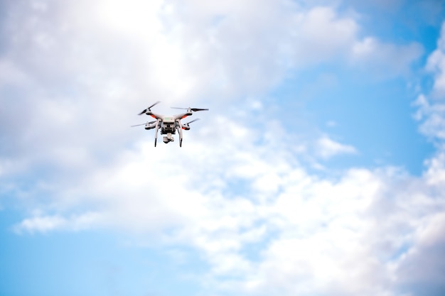 Drone Quadcopter con la cámara contra el cielo azul